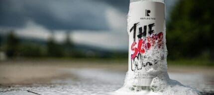 Flasche mit Schaum und Naturhintergrund
